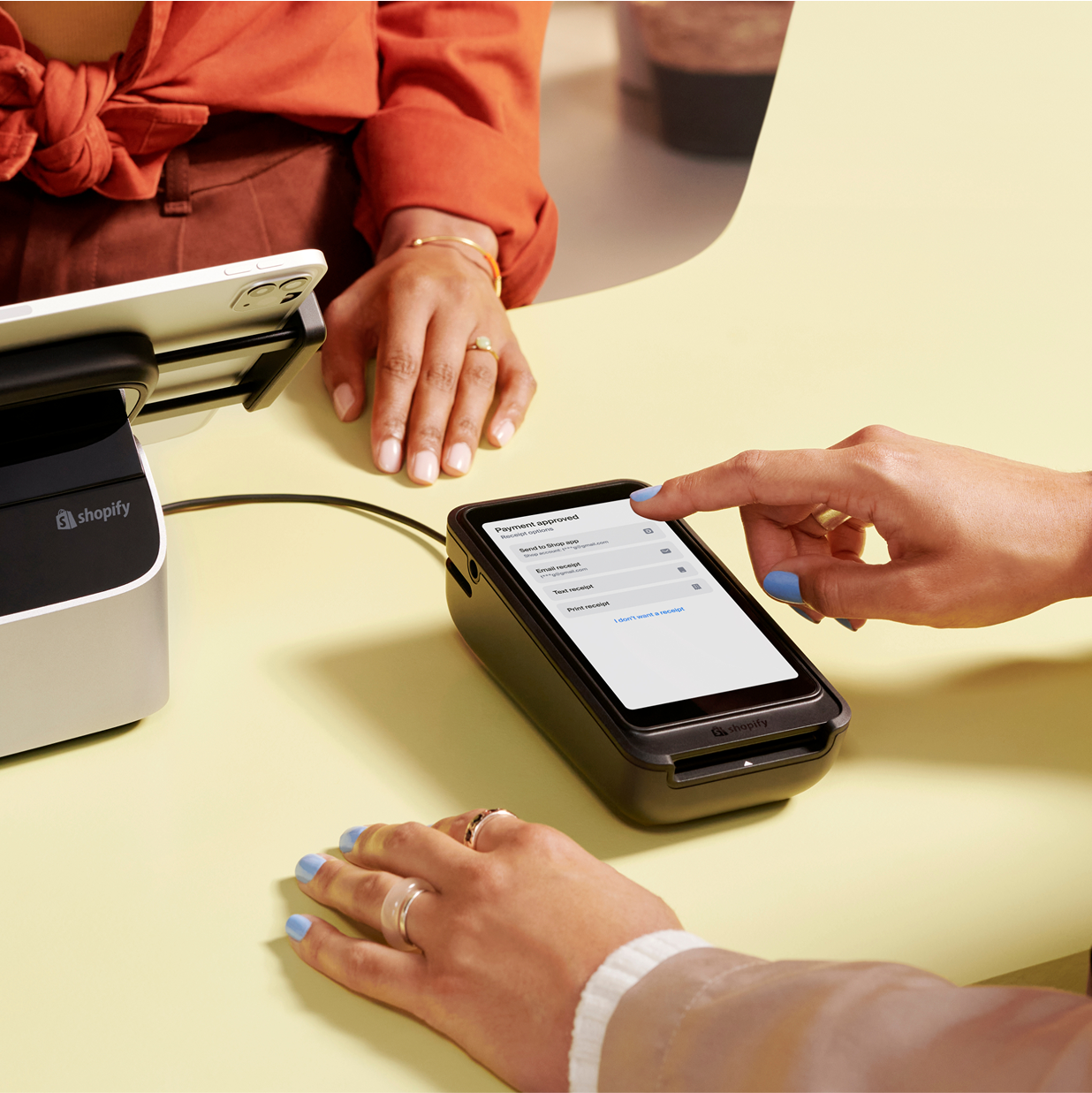A customer enters information on the POS Terminal’s screen while standing at the retail counter.